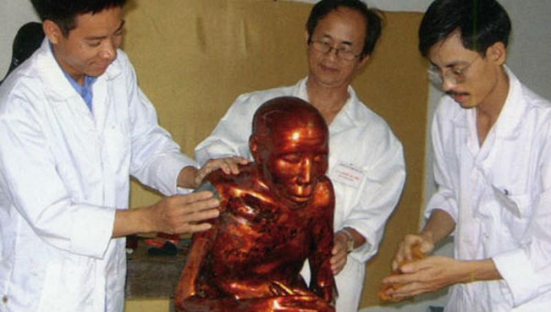 Tiến sĩ Nguyễn Lân Cường (đứng giữa) cùng các cộng sự làm công tác phục chế bức tượng thiền sư Vũ Khắc Minh tại chùa Đậu