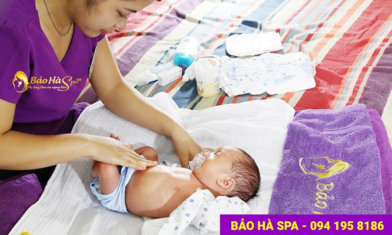 Bé được mặc quần áo cho bé và bôi tinh dầu tràm để giữ ấm cơ thể.