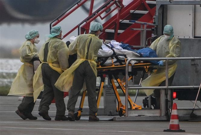 Nhân viên y tế chuyển bệnh nhân COVID-19 bằng máy bay của quân đội, tại sân bay Memmingen, Bavaria, miền Nam Đức ngày 26/11/2021. (Ảnh: AFP/TTXVN)