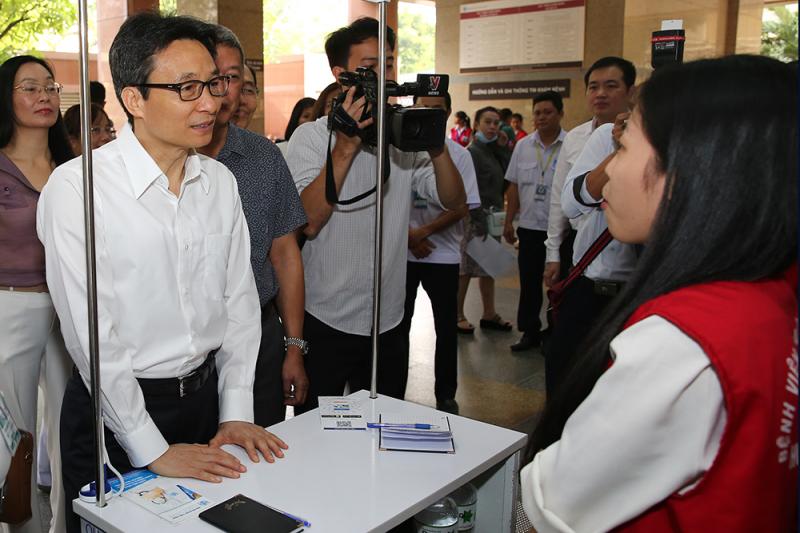Phó Thủ tướng Vũ Đức Đam trò chuyện với một sinh viên ĐH Y Dược TP. Hồ Chí Minh làm công tác hỗ trợ cho người dân đến khám
