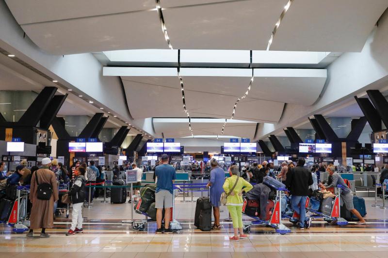 Hành khách xếp hàng tại quầy làm thủ tục ở Sân bay Quốc tế OR Tambo, Johannesburg, Nam Phi vào ngày 27.11 (Ảnh: AFP)