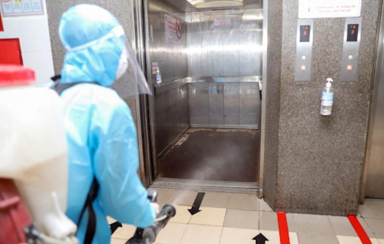 Nhân viên y tế khử khuẩn thang máy khi tòa nhà có ca nhiễm Covid-19. (Ảnh: vnexpress)