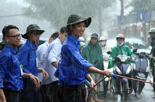 Không ngại mưa gió giúp đỡ người xung quanh qua vùng nước ngập.